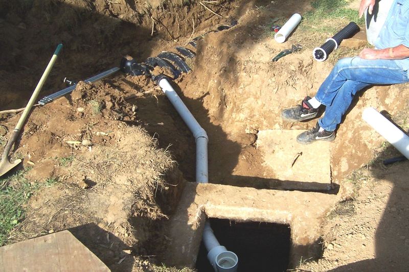 Septic tank outlet and riser pipes in an open excavation
